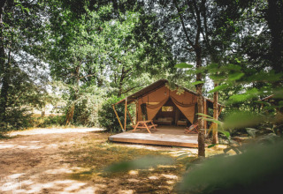 Tenda glamping immersa nel bosco presso Huttopia Vallée du Lot, parco vacanze in Nouvelle-Aquitaine, Francia.