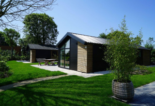Moderna cabaña Velthorst en Kagerplassen, Países Bajos, con jardines verdes, terraza y gran ventanal.