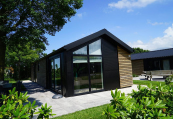 Moderne Lodge mit Holzverkleidung und großen Fenstern am Kagerplassen in den Niederlanden, im Grünen gelegen.