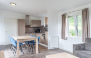 Moderne køkken og spiseplads i Pavilion-lodge ved Kagerplassen, Nederlandene, med lyse træmøbler.