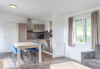 Modern kitchen and dining area at Pavilion at Kagerplassen, Netherlands, featuring wood and blue accents.