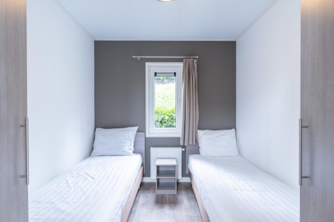 Modernes Zimmer im Pavilion am Kagerplassen in den Niederlanden mit zwei Einzelbetten und zentralem Fenster.