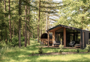 Lodge nella natura con sauna panoramica a Wilsumer Berge, Germania, immerso tra alberi alti.