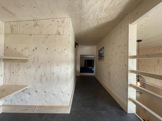 Interior hallway of Tiny House Plus lodge in De Rijp, Netherlands, featuring light wood paneling and modern style.