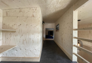 Pasillo interior de la Tiny House Plus en De Rijp, Países Bajos, con paneles de madera clara y estilo moderno.