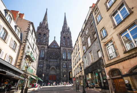 Straßenszene bei Royat, Auvergne-Rhône-Alpes, Frankreich, mit gotischer Kathedrale und alten Häusern.