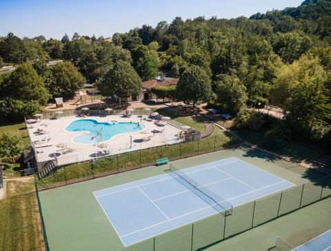 Vista aérea del parque vacacional Huttopia Royat en Auvergne-Rhône-Alpes, Francia, con piscina y cancha de tenis.