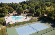 Luftfoto af ferieparken Huttopia Royat i Auvergne-Rhône-Alpes med swimmingpool og tennisbane.