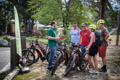 Gruppe Radfahrer bereiten Fahrräder vor im Huttopia Bourg Saint-Maurice, Auvergne-Rhône-Alpes, Frankreich.