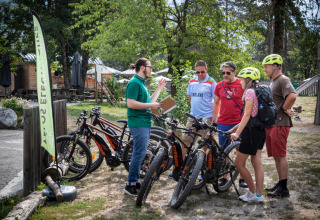 Group of cyclists preparing bikes at Huttopia Bourg Saint-Maurice, Auvergne-Rhône-Alpes, France holiday park.