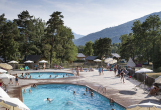 Vacanciers profitant des piscines au Huttopia Bourg Saint-Maurice, parc de vacances en Auvergne-Rhône-Alpes, France.