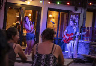 Actuación en vivo con una cantante y guitarrista en Huttopia Bourg Saint-Maurice, parque vacacional en Francia.