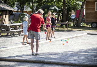 Famiglia che gioca a bocce in una giornata di sole al parco vacanze Huttopia Bourg Saint-Maurice in Alvernia-Rodano-Alpi.