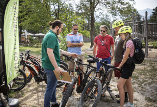 Groep mensen ontdekt elektrische fietsen in Huttopia Bourg Saint-Maurice, vakantiepark in Auvergne-Rhône-Alpes.