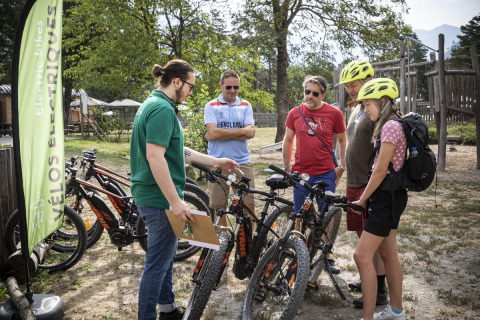 Groep mensen ontdekt elektrische fietsen in Huttopia Bourg Saint-Maurice, vakantiepark in Auvergne-Rhône-Alpes.