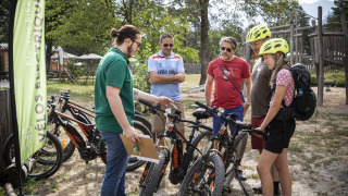 Personas descubren bicicletas eléctricas en Huttopia Bourg Saint-Maurice, un parque vacacional en Auvernia-Ródano-Alpes.