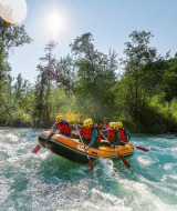 Grupo haciendo rafting en aguas bravas cerca de Bourg-Saint-Maurice, rodeado de naturaleza y agua cristalina.