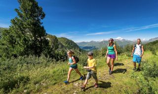 Familia de excursión cerca de Bourg-Saint-Maurice, Francia, rodeada de montañas y naturaleza impresionante.