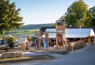 Houten speelplein en glijbaan bij Huttopia Meursault, gelegen te midden van de Bourgondische wijngaarden.