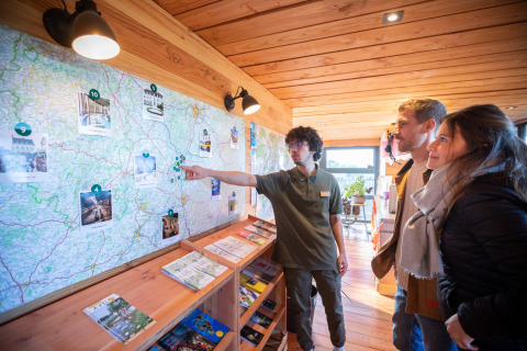 Visitors get travel advice from a staff member at Huttopia Meursault, Bourgogne-Franche-Comté, France.