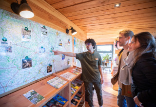Visitors get travel advice from a staff member at Huttopia Meursault, Bourgogne-Franche-Comté, France.