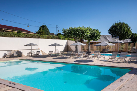 Piscina al aire libre con tumbonas y sombrillas en Huttopia Meursault, Bourgogne-Franche-Comté, Francia.