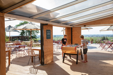 Bambini giocano a calcetto su una terrazza coperta al villaggio Huttopia Meursault, Borgogna, Francia.