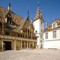 Edificio histórico con techo de azulejos coloridos en Meursault, Bourgogne-Franche-Comté, Francia.
