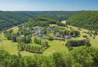 Vue aérienne d’Huttopia Vallée de la Semois, parc de vacances à Namur, Belgique, entouré de collines verdoyantes.