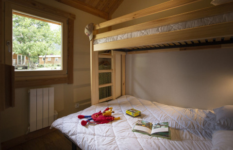 Acogedora habitación con literas y ventana en Montana Chalet, Huttopia Bourg Saint-Maurice, Francia.
