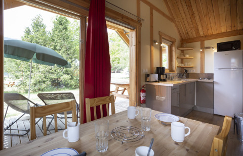 Hyggelig Montana Chalet-hytte på Huttopia Bourg Saint-Maurice med spisebord, tekøkken og udendørs terrasse.