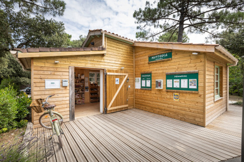 Reception building at Huttopia Oléron Les Chênes Verts holiday park, surrounded by trees in Nouvelle-Aquitaine, France.