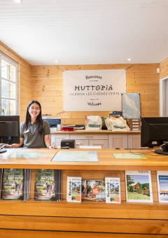 Rezeptionistin hinter dem Schalter im Huttopia Oléron Les Chênes Verts Ferienpark in Nouvelle-Aquitaine, Frankreich.