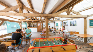 Gemeinschaftsraum im Huttopia Oléron Les Chênes Verts mit Tischfußball und Sitzgelegenheiten.