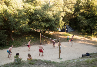 Vakantiegangers spelen volleybal op het zand bij Huttopia Oléron Les Chênes Verts in Frankrijk.