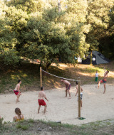 Huéspedes juegan al voleibol en la arena en Huttopia Oléron Les Chênes Verts, un parque vacacional en Francia.