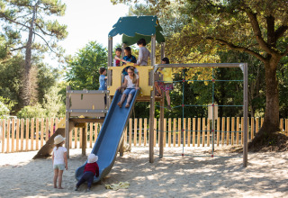 Kinderen spelen op een speeltuin met glijbaan in Huttopia Oléron Les Chênes Verts in Nouvelle-Aquitaine, Frankrijk.