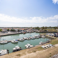 Hafen mit Booten und Autos in Dolus d'Oleron, Nouvelle-Aquitaine, Frankreich an einem sonnigen Tag.