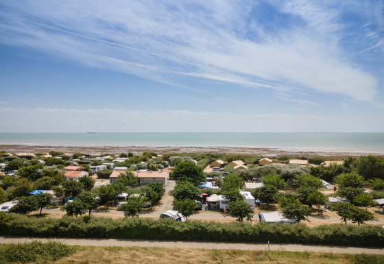 Udsigt over ferieparken Huttopia Côte Sauvage ved kysten i Nouvelle-Aquitaine, Frankrig, med hav og hytter.
