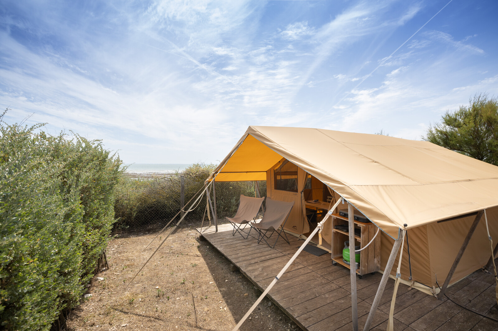 Safaritent Bungalow Classic bij Huttopia Côte Sauvage in Frankrijk met stoelen en houten terras.