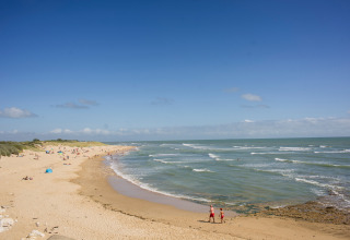 Zicht op het strand van Huttopia Côte Sauvage vakantiedomein in Nouvelle-Aquitaine, Frankrijk, blauwe lucht.