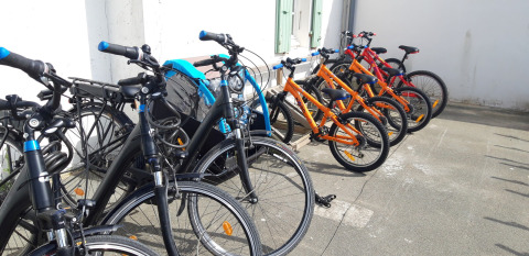 Varias bicicletas de alquiler de colores estacionadas en fila en el parque vacacional Huttopia Côte Sauvage.