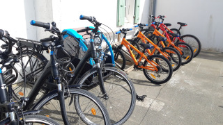 A row of colorful rental bicycles parked and ready for guests at Huttopia Côte Sauvage holiday park.