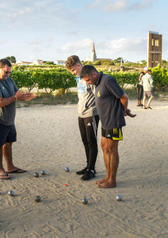 People playing pétanque on a sandy court at Huttopia Côte Sauvage holiday park, Nouvelle-Aquitaine, France.