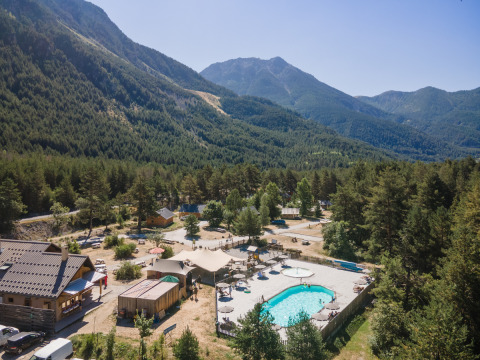 Parque vacacional Huttopia la Clarée en Provence-Alpes-Côte d’Azur, Francia, con piscina y vistas a las montañas.
