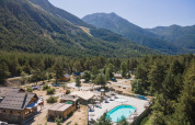 Feriepark Huttopia la Clarée i Provence-Alpes-Côte d’Azur, Frankrig, med pool og udsigt til bjerge.