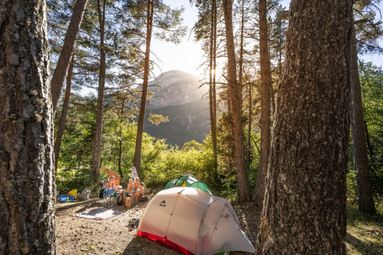 Kampeerplek met tenten in het bos en bergen op de achtergrond in Provence-Alpes-Côte d’Azur, Frankrijk.