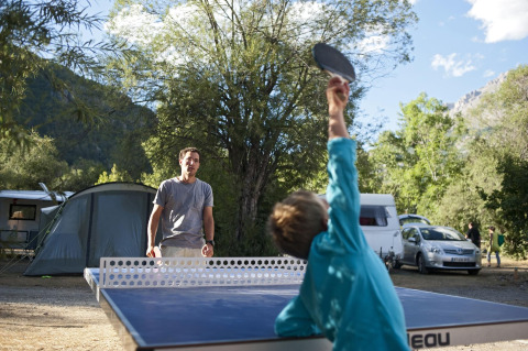 Dos personas juegan al tenis de mesa al aire libre en un camping de Provence-Alpes-Côte d’Azur, Francia.