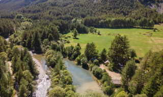 Vista aérea de bosques, un río y campos verdes cerca de Val-Des-Près, Provence-Alpes-Côte d’Azur, Francia.
