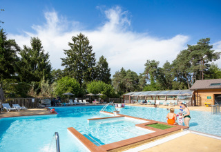 Openluchtzwembad met vakantiegangers en ligstoelen bij Camping La Pinède - Excenevex in Frankrijk.